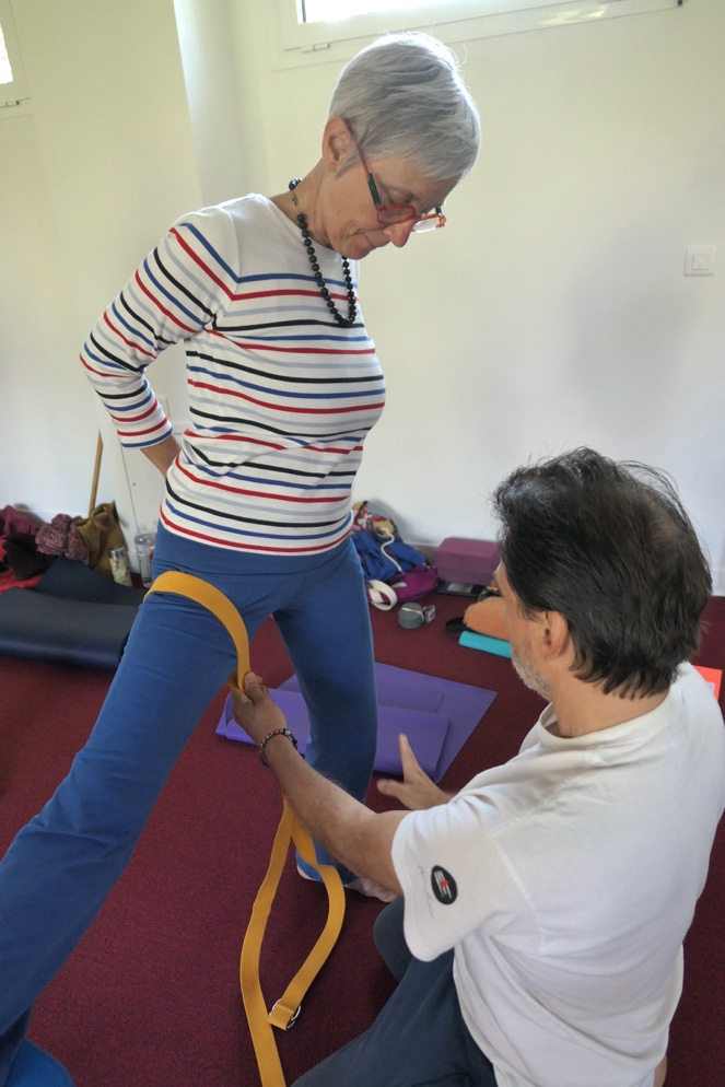 Séance de yoga senior : Stéphane accompagne une participante avec une sangle