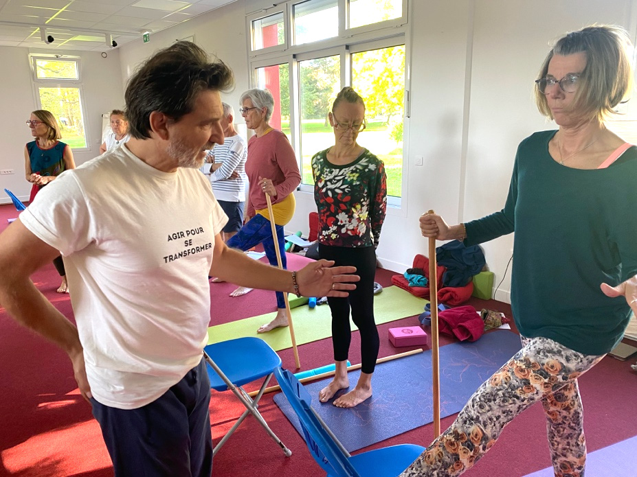 Stéphane Anselmino guide un groupe de yoga adapté avec l'aide de bâtons de marche